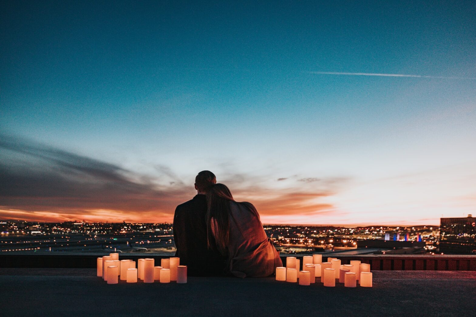couple sitting on the field facing the city, patchouli oil for love, patchouli perfume for love