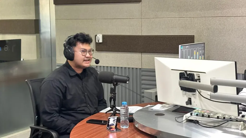 Farel Alfarizy of Global Essential Oil speaking into a microphone during a talk show at RRI PRO 1 Jakarta.