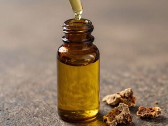 Bottle of golden frankincense oil with resin pieces.