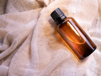 a bottle of perfume sitting on top of a white cloth